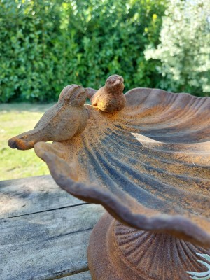 Roestige vogelvoederschaal op voet 